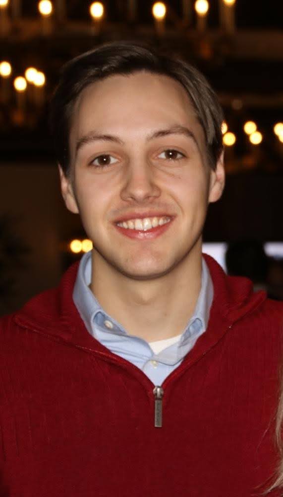 Jon Pekkarinen wearing a red quarter-zip over a dress shirt
